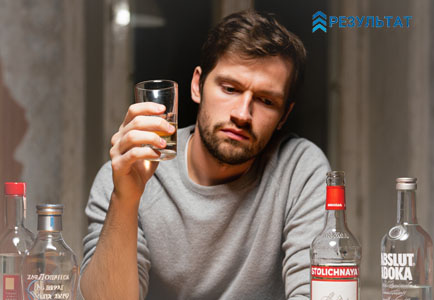 Мужчина сидит и пьет алкоголь
